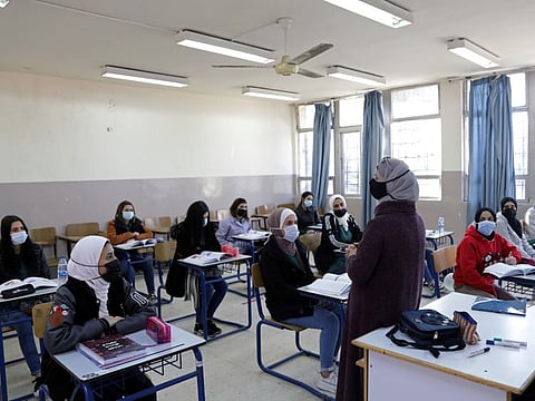 Students wearing protective face masks attend a class following the reopening of their school, after the government eased the coronavirus disease (COVID-19) restrictions in Amman, Jordan February 7, 2021. 
