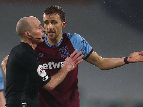 Mike Dean and Tomas Soucek.