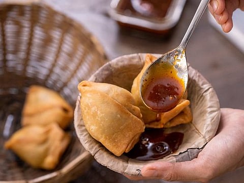 Singara with sweet chutney or fried pastry filled with spicy potatoes 