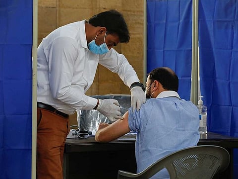 A health worker receives a dose of Sinopharm's coronavirus vaccine in Karachi, Pakistan.