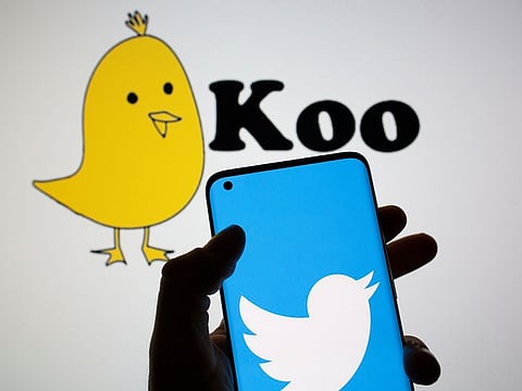 Twitter logo is seen on smartphone in front of displayed Koo app logo in this illustration. 