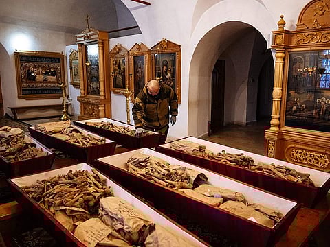 A municipal employee arranges coffins containing remains of Russian and French soldiers who died during Napoleon's 1812 retreat, in a small church in the monastery of John the Precursor in the town of  Vyazma. 