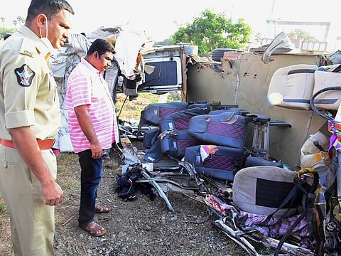 Police inspect the mangled remains of a  mini bus after collided with a truck on the Hyderabad-Bengaluru national highway, near Veldurthi in Kurnool district of Andhra Pradesh, Sunday early morning. At least 14 people belonging to the same family were killed and four others were critically injured.