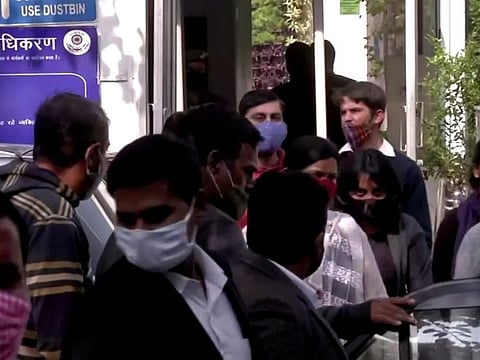 Activist Disha Ravi is escorted by police officials as she walks out of the court in New Delhi, on February 14, 2021. 