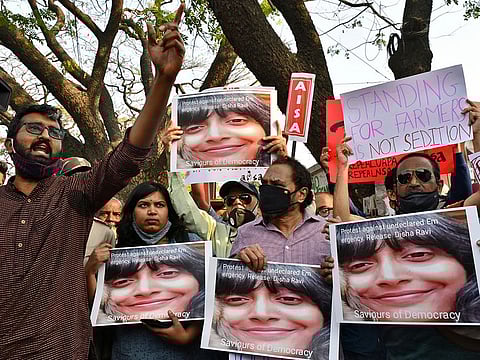 People hold placards during a protest against the arrest of climate activist Disha Ravi, in Bengaluru, on February 15, 2021. 