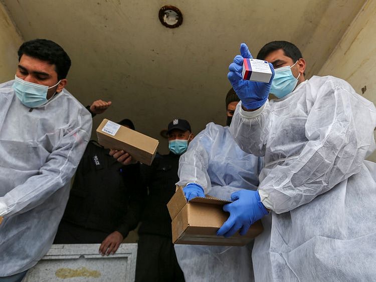 Palestinian workers unload the first shipment of coronavirus vaccines, in the southern Gaza Strip February February 17, 2021.