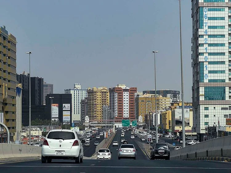 Stock Ajman skyline taxi bus street