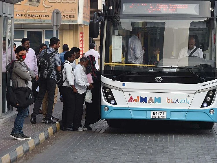 Stock Ajman skyline taxi bus street