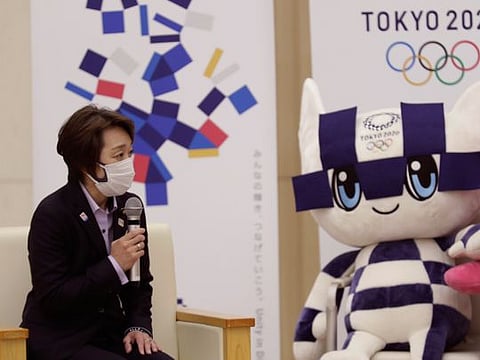 Seiko Hashimoto, the newly appointed President of Tokyo 2020 Olympics Organizing Committee,  speaks to the media with the Games mascot keeping a watch.