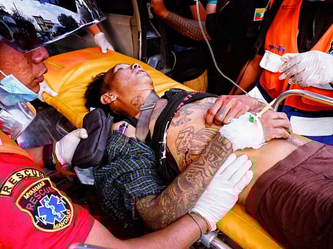 An injured man is carried by rescue workers after protests against the military coup, in Mandalay, Myanmar, February 20, 2021. 
