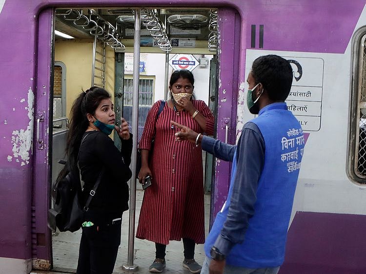 A municipal worker gives a commuter a penalty for not using a face mask at Chhatrapati Shivaji Maharaj Terminus in Mumbai, on February 20, 2021. AP 