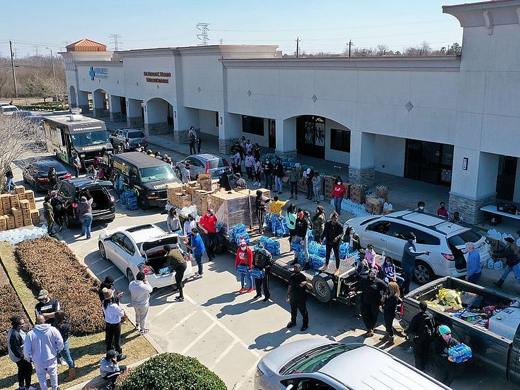 Volunteers pass out water during a water distribution event at the Fountain Life Center in Houston, Texas. 