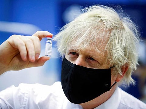 Britain's Prime Minister Boris Johnson holds a vial of an Oxford-AstraZeneca COVID-19 vaccine, during his visit at a vaccination centre at Cwmbran Stadium in Cwmbran, south Wales, Britain, February 17, 2021. 