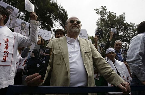 A file photo taken on April 30, 2010, shows Anis Naccache, a Lebanese militant notorious for his role in the 1975 Opec hostage-taking in Vienna and the attempted assassination near Paris of Iran's former premier, holding a picture of Georges Ibrahim Abdallah during a demonstration outside the French embassy in the capital Beirut. Naccache died in Damascus on February 22, 2021.