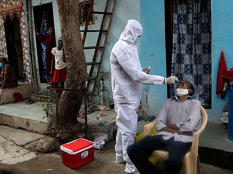 A health worker collects swab samples during a door-to-door screening for COVID-19 people at Dharavi, one of Asia's largest slums, in Mumbai, India, Tuesday, Feb. 23, 2021. 