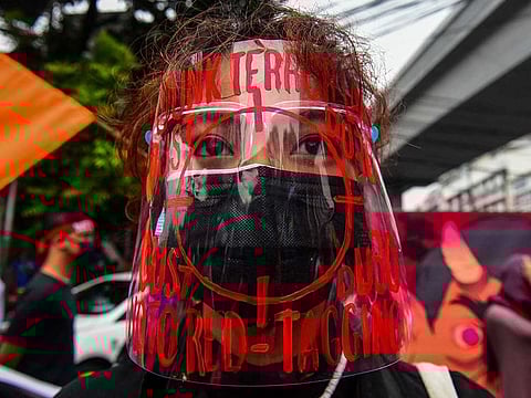 A protester wearing a face shield decorated with slogans against "red-tagging", as she takes part in a protest to commemorate International Human Rights Day near the presidential palace in Manila.