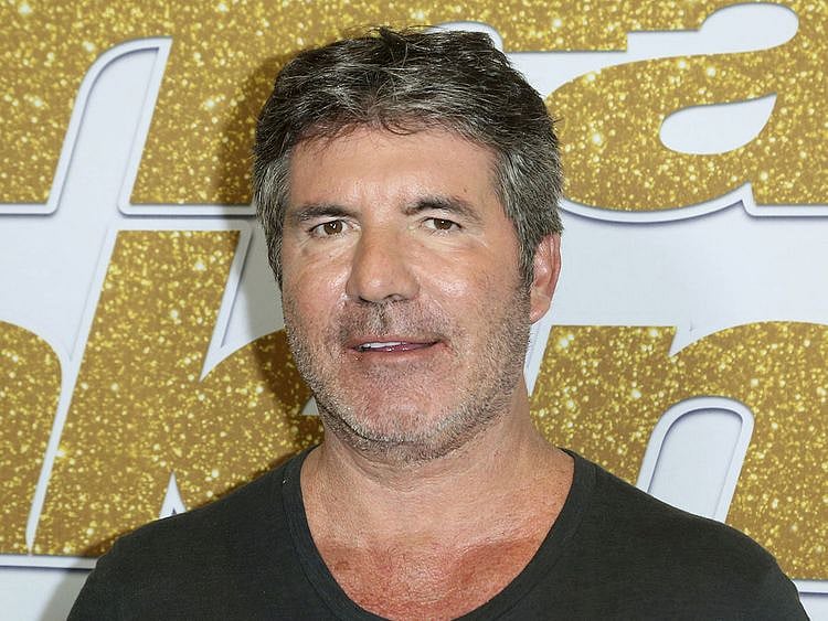 FIE - In this Aug. 28, 2018, file photo, Simon Cowell arrives at the "America's Got Talent" Season 13 Week 3 red carpet at the Dolby Theatre in Los Angeles. Cowell broke his back Saturday, Aug. 8, 2020, while testing his new electric bicycle at his home in California. (Photo by Willy Sanjuan/Invision/AP, File)