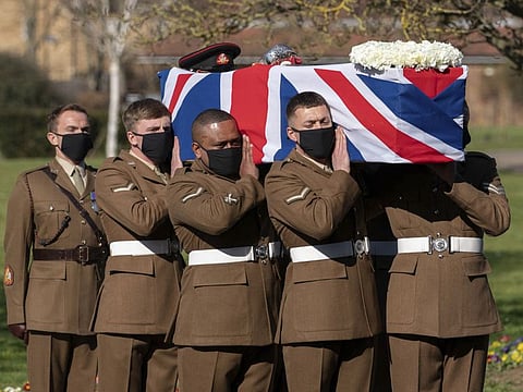 The coffin of Captain Sir Tom Moore is carried by members of the Armed Forces during his funeral, at Bedford Crematorium, in Bedford, England, Saturday, Feb. 27, 2021. 