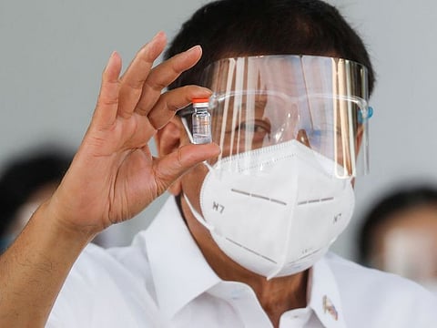 Philippine President Rodrigo Duterte holds a vial of Sinovac’s coronavirus disease (COVID-19) vaccine, the first COVID-19 vaccine to arrive in the country, at Villamor Air Base, Pasay City, Metro Manila, Philippines.
