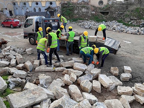Unesco workers transport pieces of marble from near 'Hosh Al Bieaa' (Church square) to make a room for the upcoming visit of Pope Francis to the site in the old city of Mosul, Iraq February 22, 2021. 