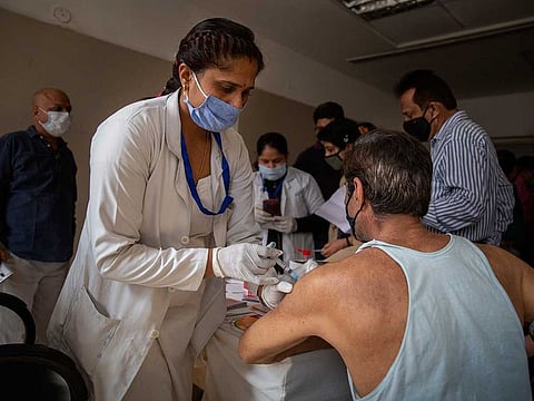 A health worker administers COVISHIELD vaccine to an elderly man at a government hospital in Noida, a suburb of New Delhi, India, Monday, March 1, 2021.