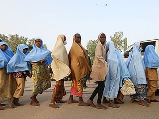 Girls who were kidnapped from a boarding school in the northwest Nigerian state of Zamfara, walk in line after their release in Zamfara, Nigeria March 2, 2021. 