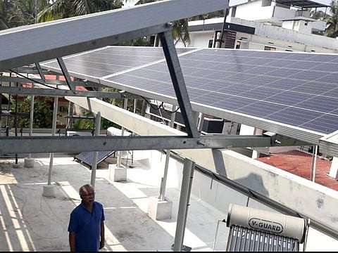 Govindan Satheeshan stands under the solar panels installed on his rooftop in the southern Indian state of Kerala, January 28, 2021. 