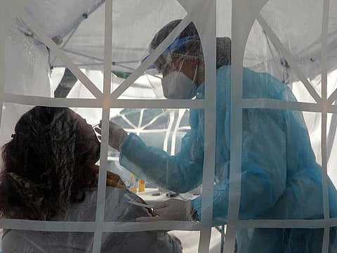 A medical worker takes a swab sample in a tent outside a pharmacy where rapid COVID-19 swab tests are carried out amid the coronavirus disease (COVID-19) outbreak in Nice, France, March 4, 2021. 
