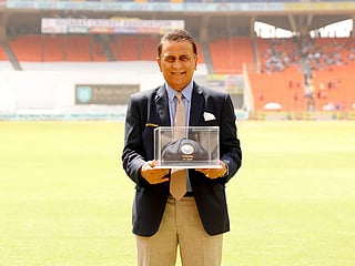 Sunil Gavaskar poses for the photographers with a 'blue baggy' cap, presented to him on the 50th anniversary of his memorable Test debut, by BCCI during Ahmedabad Test.