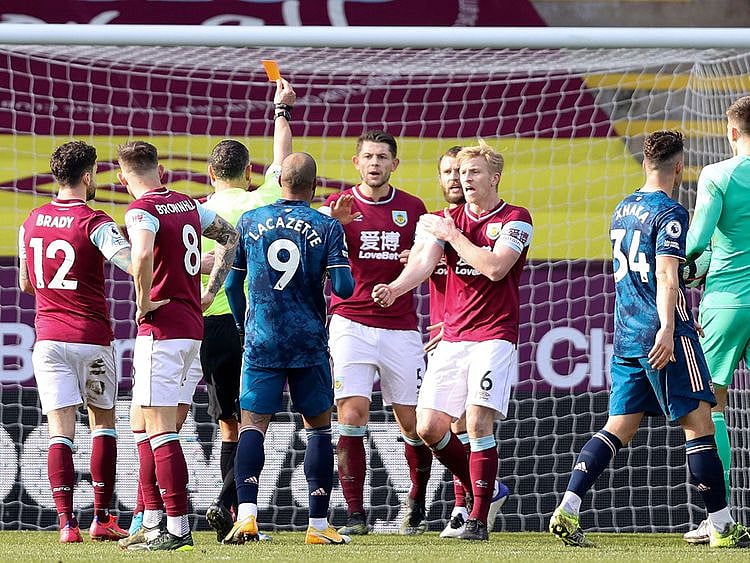 Referee Andre Marriner initially shows a red card for handball to send off Burnley's Dutch defender Erik Pieters, a decision that was reversed after VAR review 