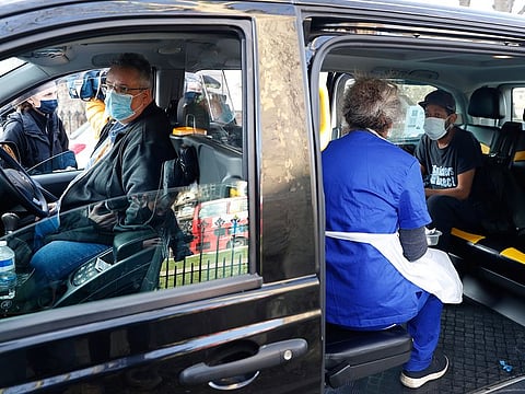Dr Tamara Joffe prepares to administer a COVID-19 jab using the AstraZeneca vaccine to Leslie Reid in the back of a London Taxi cab during the pilot project of pop up vaccination drive 'Vaxi Taxi' in Kilburn, London.
