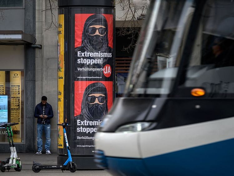 A tram passes by campaign posters, in favour of the "burqa ban" initiative reading in German: "Stop extremism!" on March 3, 2021 in the streets of Zurich, ahead of a nationwide vote on March 7, 2021 by Swiss citizen on whether to ban full facial coverings in public places. - Polls indicate a majority support the move, in a vote that comes after years of debate following similar bans in other European countries -- and in some Muslim-majority states.