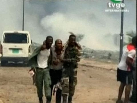 This video grab obtained by AFPTV from TVGE on March 7, 2021 shows an injured man being assisted by soldiers in Bata, Equatorial Guinea.  AFP
