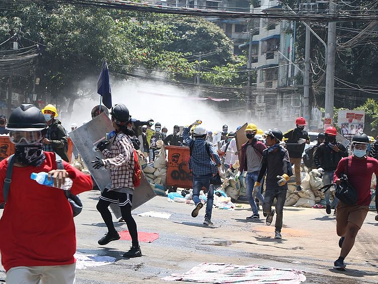 Protesters are dispersed as police fire tear gas during a demonstration in Yangon, on March 8, 2021.  