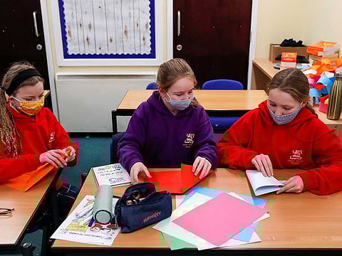 Students fold paper during a lesson at Heath Mount school as schools reopen in England, amid the coronavirus disease (COVID-19) pandemic, in Watton at Stone, Hertfordshire, Britain March 8, 2021. 