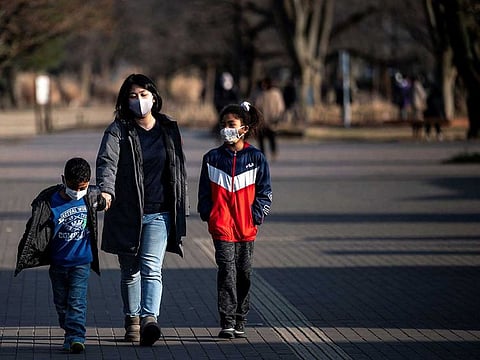 This picture taken on January 18, 2021 shows Fukushima evacuee and mother of four Megumi Okada (C) walking with some of her children in a park in Tokyo. A decade after a massive earthquake unleashed a tsunami that sent the Fukushima Daiichi nuclear plant into meltdown, areas affected by radiation are still wrestling with the question: how do you rebuild a community? 