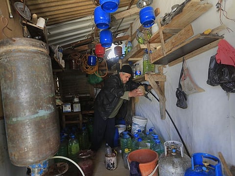 A Syrian displaced man Mohammed Zakaria, 53, who fled his Syrian hometown of Homs in 2012, works at his gas and oil shop which is at the entrance of his tent at a refugee camp, in Bar Elias, in eastern Lebanon’s Bekaa valley, Friday, March 5, 2021. 