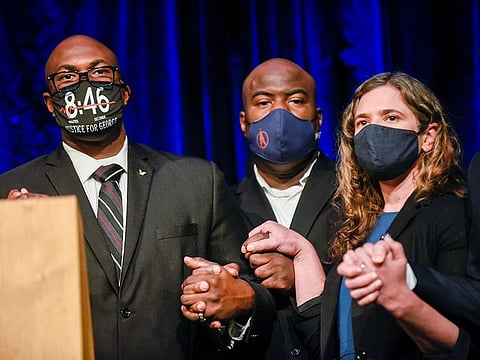 George Floyd's brothers, Philonise and Rodney Floyd, hold hands with City Council President Lisa Bender during a news conference announcing a $27 million dollar settlement with the City of Minneapolis at the Minneapolis Convention Center at the end of the first week of the trial of former police Derek Chauvin, who is facing murder charges in the death of George Floyd, in Minneapolis.  