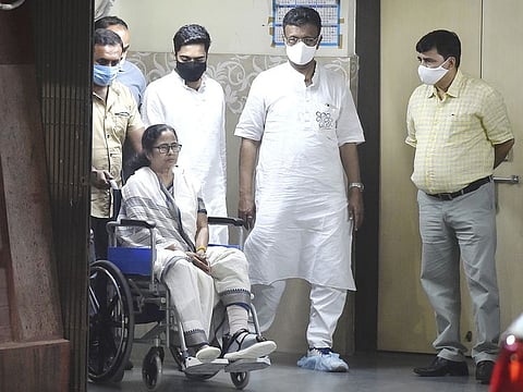 West Bengal Chief Minister Mamata Banerjee, sitting in a wheel-chair, seen while being discharged from SSKM Hospital in Kolkata, on Friday. 