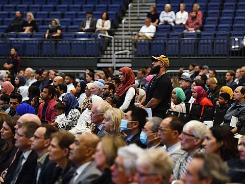 People listen as the names of the people who lost their lives in the terrorist attacks are read out during a national remembrance service in Christchurch on March 13, 2021, to mark two years since the Christchurch mosque attacks in which 51 people were killed and dozens were injured following the mass shooting on March 15, 2019.  
