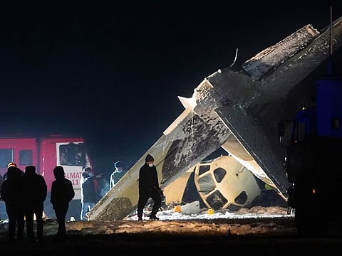 Emergency employees work at the side of the crashed Soviet-built An-26 two-engine turboprop at the airport in Almaty, Kazakhstan, on Saturday. 