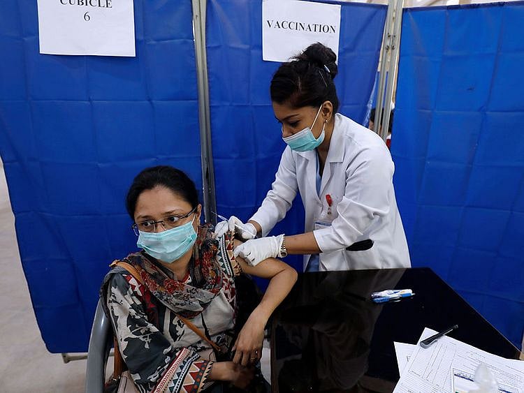 A woman receives the first dose of the coronavirus disease (COVID-19) vaccine, as the government started vaccination for the general public, starting with elderly people, at a vaccination center in Karachi, Pakistan March 10, 2021. 