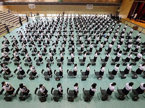 Japanese high school students attend a ceremony for the reopening of their school in Higashiosaka, Osaka prefecture, last summer. Many schools require students to have straight black hair. 