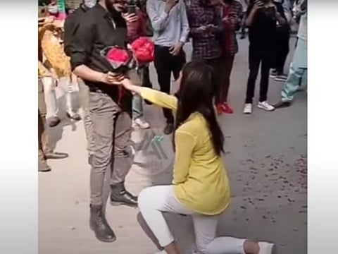 In the clip, a female university student gets down on one knee and proposes to her boyfriend; the couple can then be seen hugging and holding bouquets of flowers as onlookers cheer them on and film the scene.