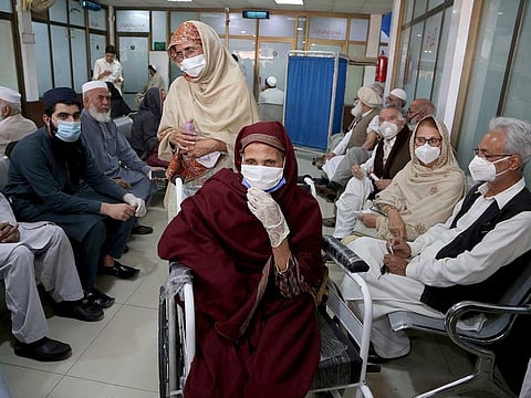 People wait their turn to receive a Sinopharm coronavirus vaccine at a vaccination centre, in Peshawar, Pakistan, Wednesday, March 10, 2021.