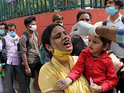 A healthcare worker collects a swab sample from a woman amidst the spread of coronavirus disease (COVID-19), at a bus station, in New Delhi, India March 16, 2021. 