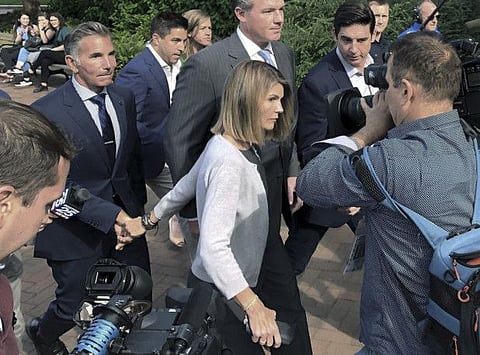 In this Aug. 27, 2019, file photo, Lori Loughlin departs federal court with her husband, clothing designer Mossimo Giannulli, left, in Boston, after a hearing in a nationwide college admissions bribery scandal.