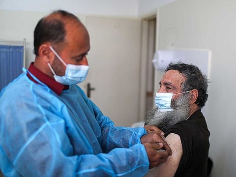 A health worker vaccinates a Palestinian man against the coronavirus disease (COVID-19), in Gaza City March 17, 2021. 