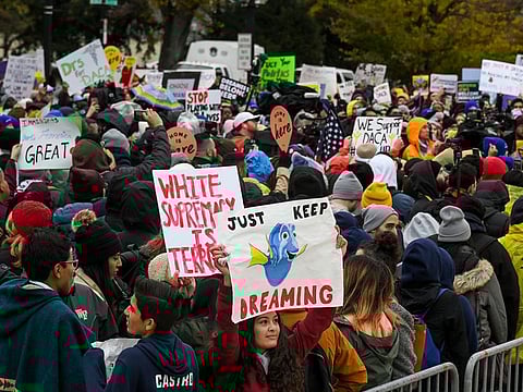 Anahi Andino, 17, of Baltimore, holds a "Just Keep Dreaming" sign as demonstrators gather in front of the Supreme Court in 2019. 