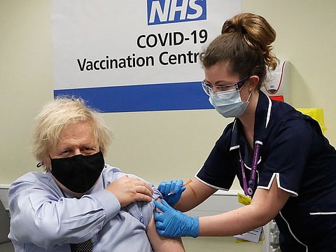 Britain's Prime Minister Boris Johnson receives the first dose of the AstraZeneca vaccine administered by nurse and Clinical Pod Lead, Lily Harrington at St.Thomas' Hospital in London, Friday, March 19, 2021. 